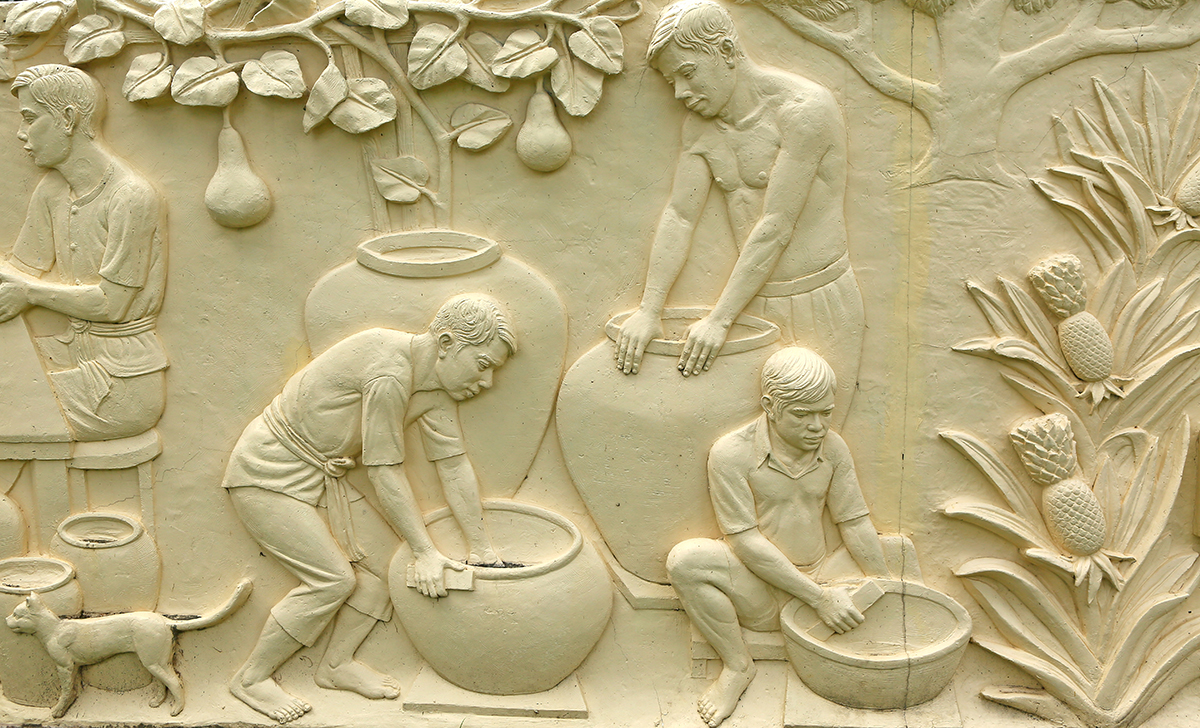 A stone carving of men working in pots