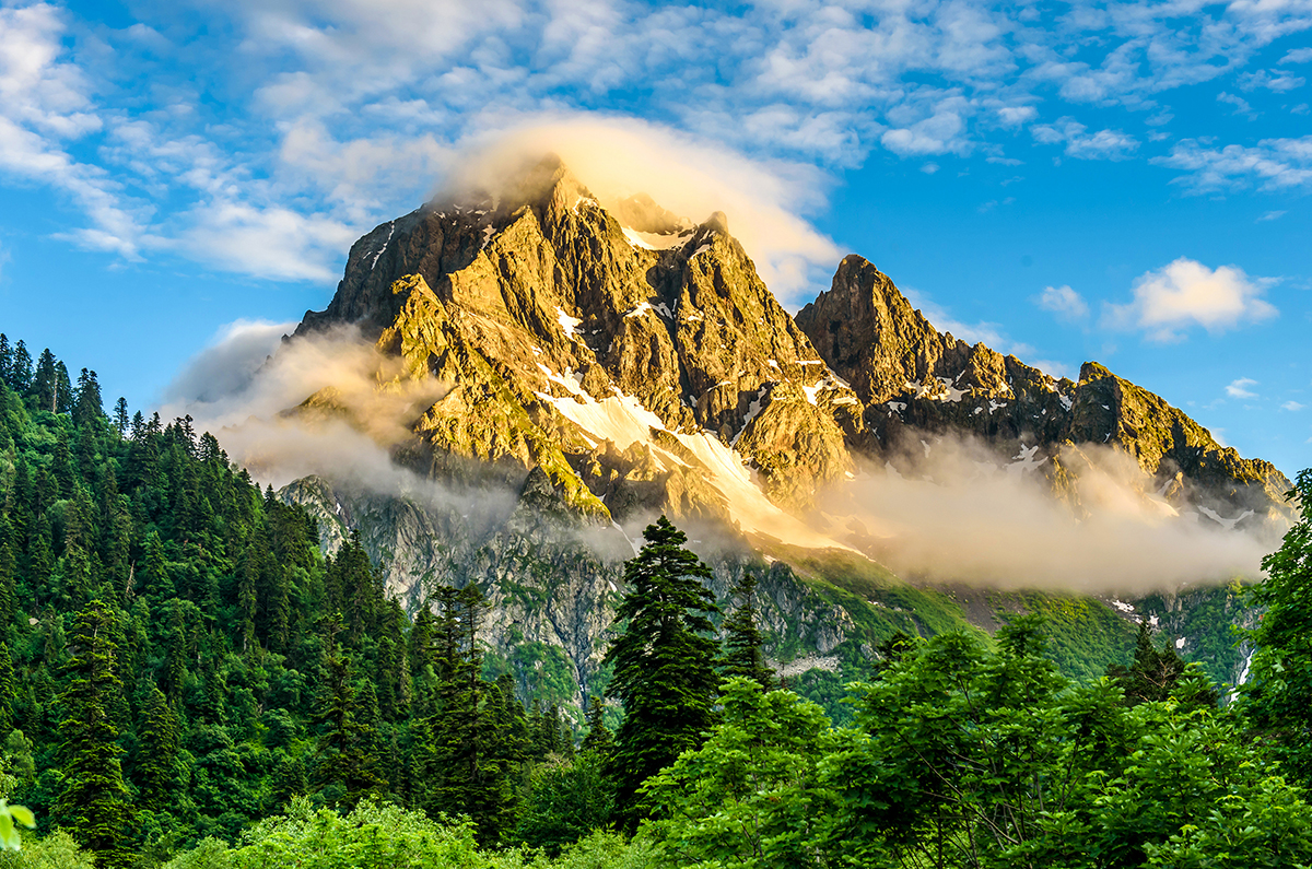 A mountain with clouds and trees