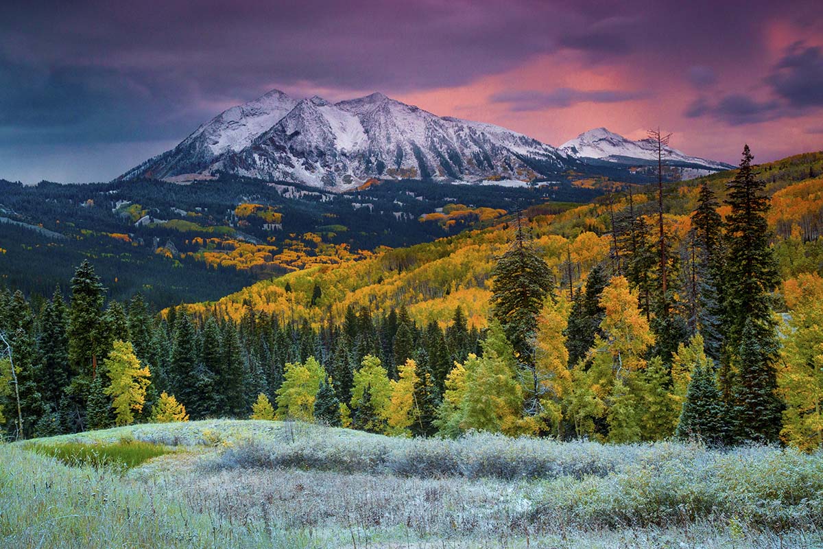 A mountain range with snow covered mountains in the background