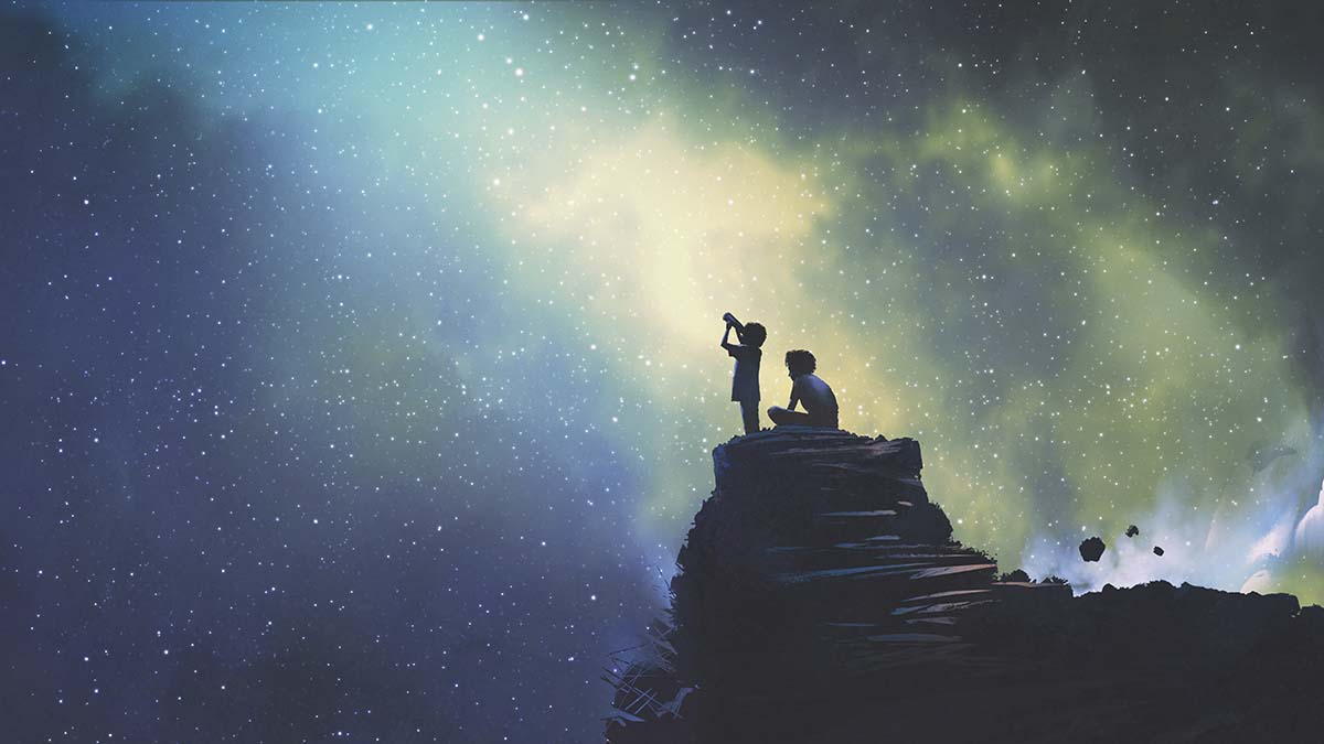 Two children on a rock looking at stars
