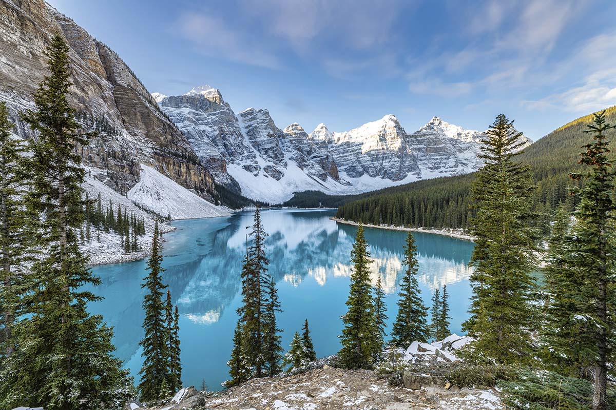 A blue lake surrounded by snow covered mountains