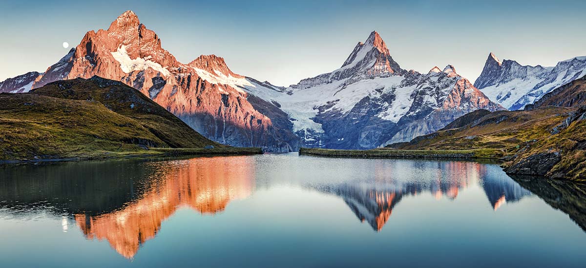 A lake with snow covered mountains and a blue sky