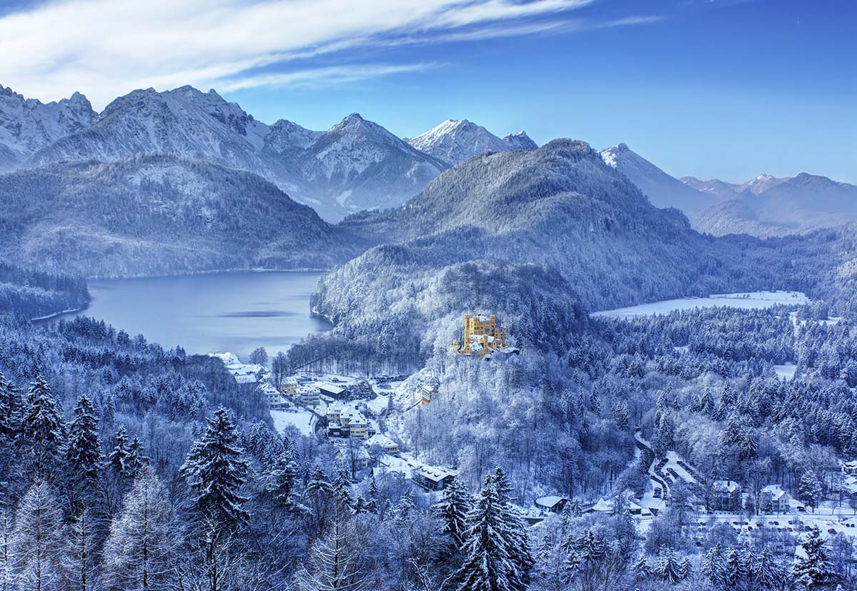 A snowy mountain landscape with a lake and a building