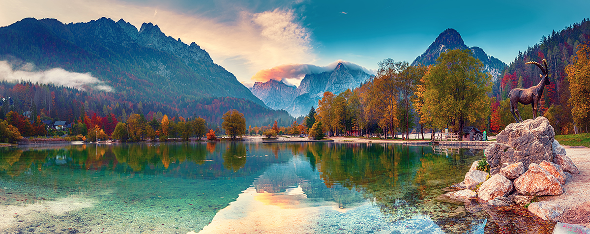 A lake with trees and mountains in the background