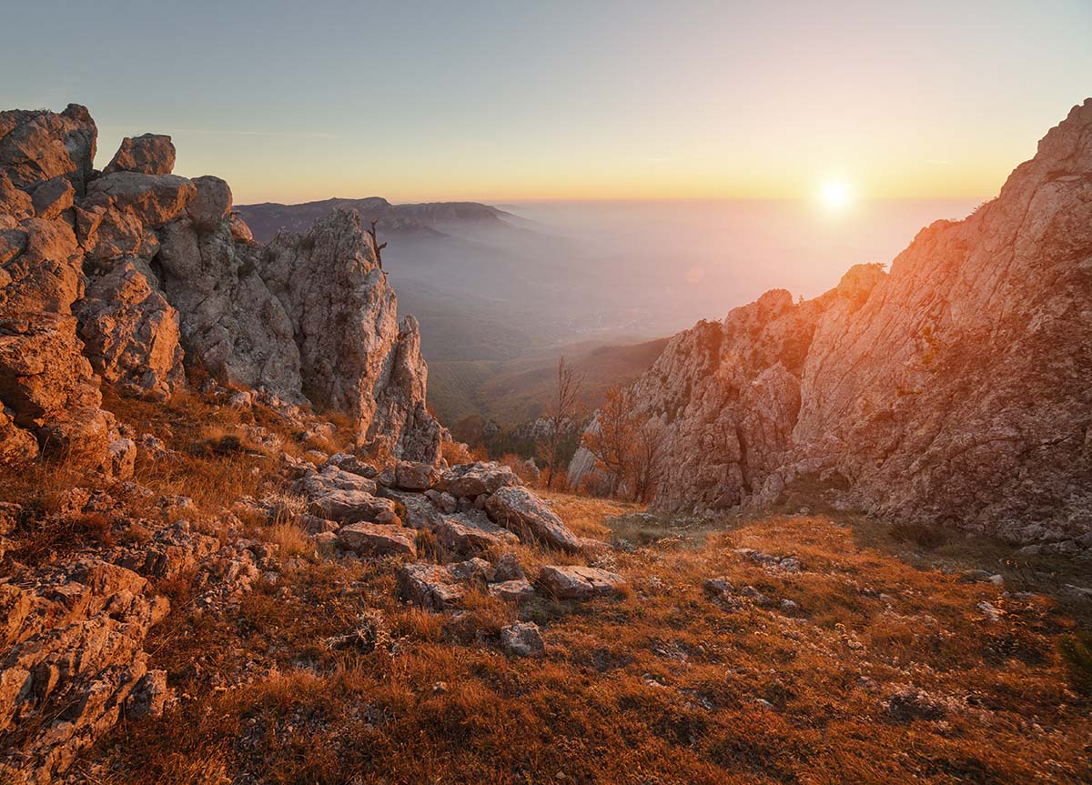 A rocky mountains with a sunset