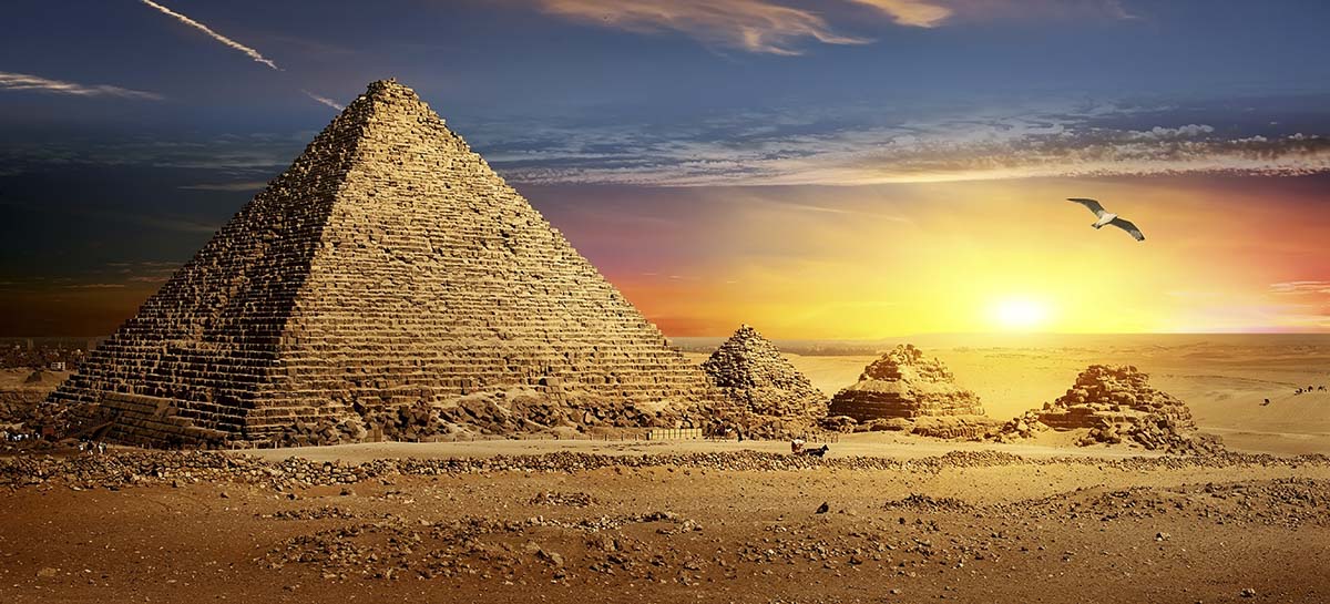 A group of pyramids in a desert with Great Pyramid of Giza in the background