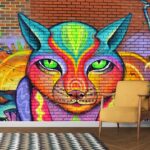 A colorful cat mural on a brick wall