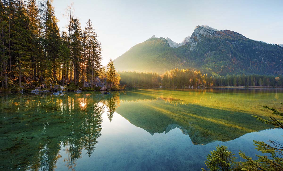 A lake with trees and mountains in the background