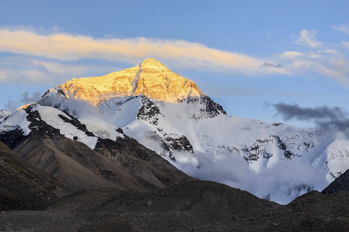 A mountain with snow and clouds